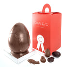 Oeuf de paques en chocolat au lait garni de petite fritures de paques : oeufs fourrés au praliné et petite fritures en chocolat. par cavaletti paris, chocolatier artisanal. 