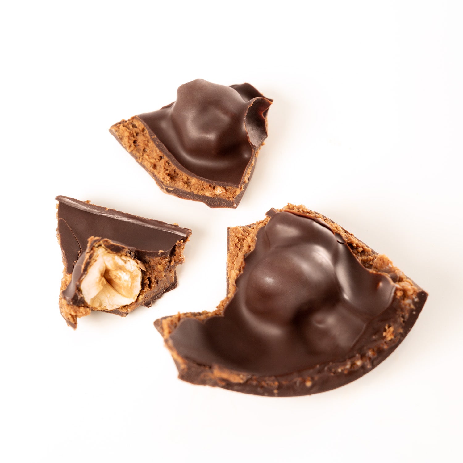 focus sur l'intérieur de l'oeuf de paques en chocolat noir artisanal, au praliné aux vrai morceaux de noisettes.  